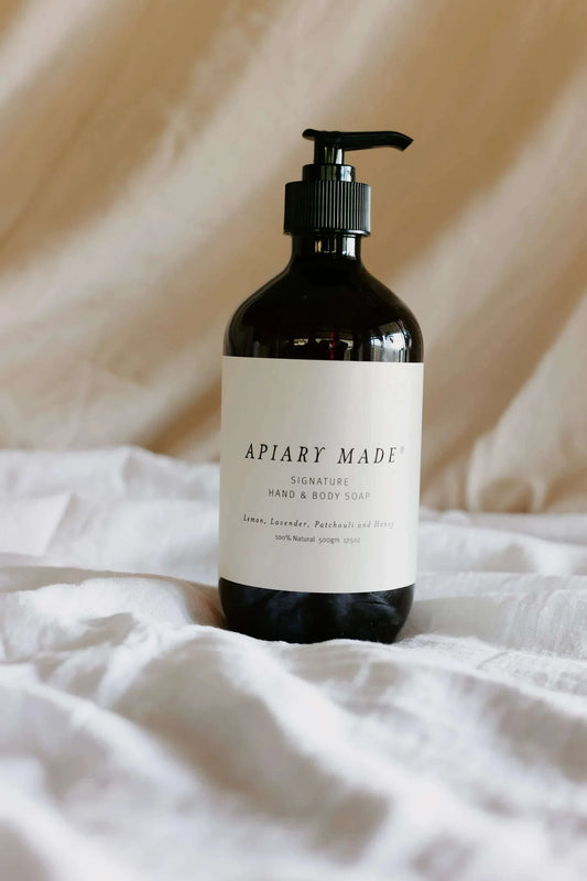 Apiary Made Signature Liquid Hand & Body Soap bottle on fabric background.