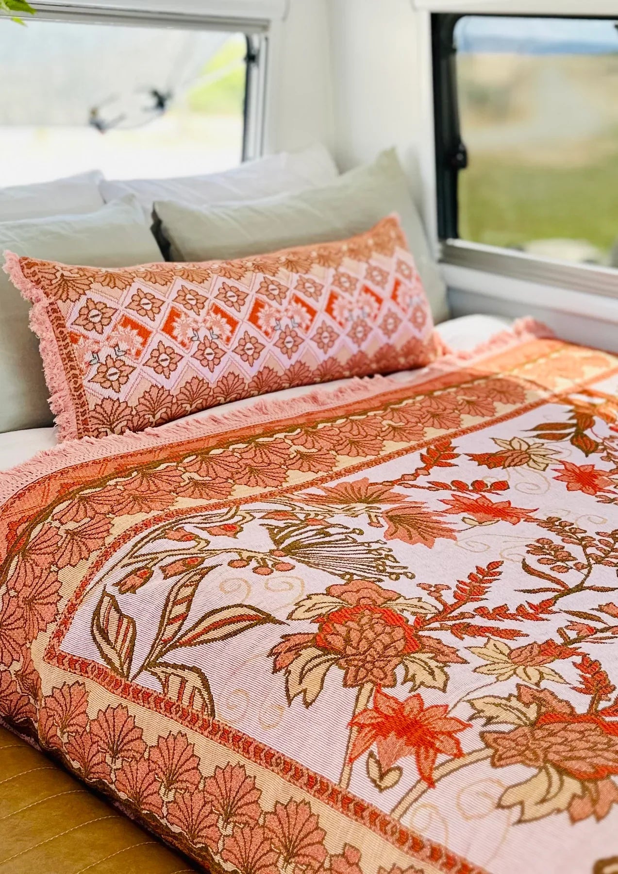 Emily Picnic Rug/Woven Throw featuring Australian botanical design in pink, rusty red, and tan tones with tassel trimming.