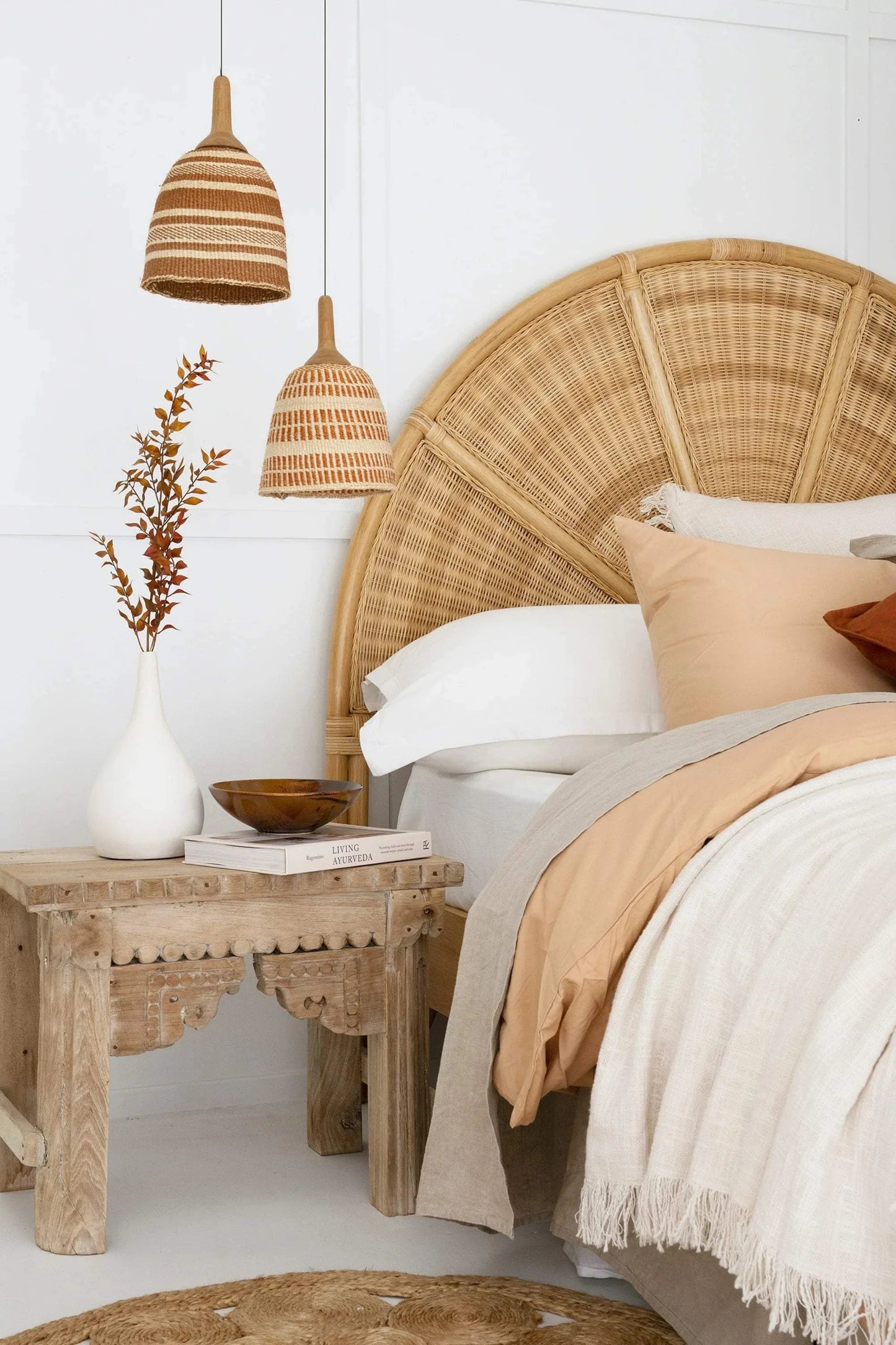 Bespoke woven pendant lights in creamy caramel tones hanging in a cozy bedroom setting.