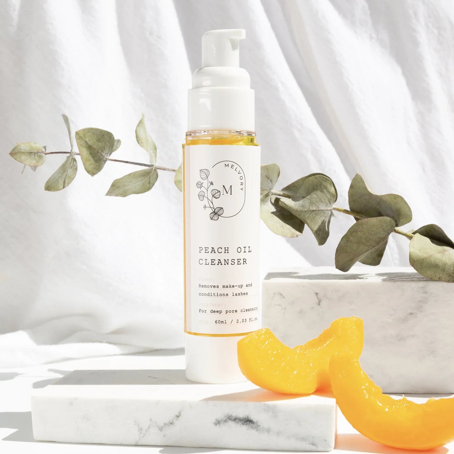 Melvory Peach Oil Cleanser bottle with peaches and greenery, for makeup removal and lash conditioning.