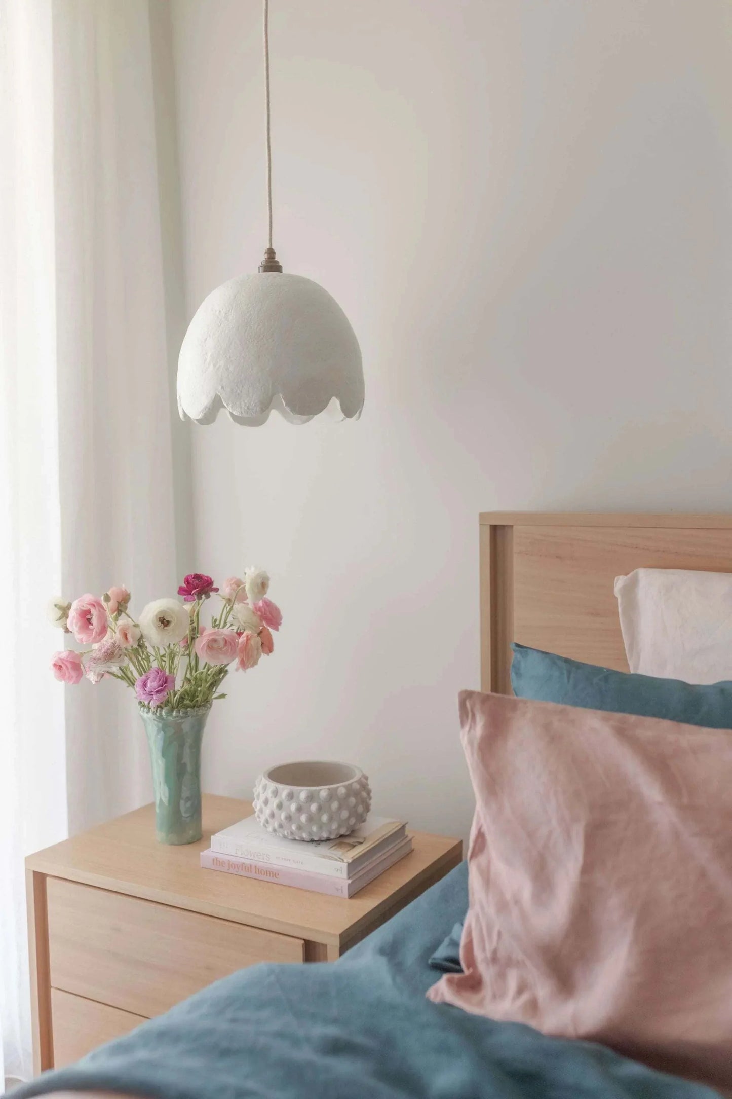 Her Hands - Pulp Pendant Lights in scallop design hanging in a cozy bedroom setting.