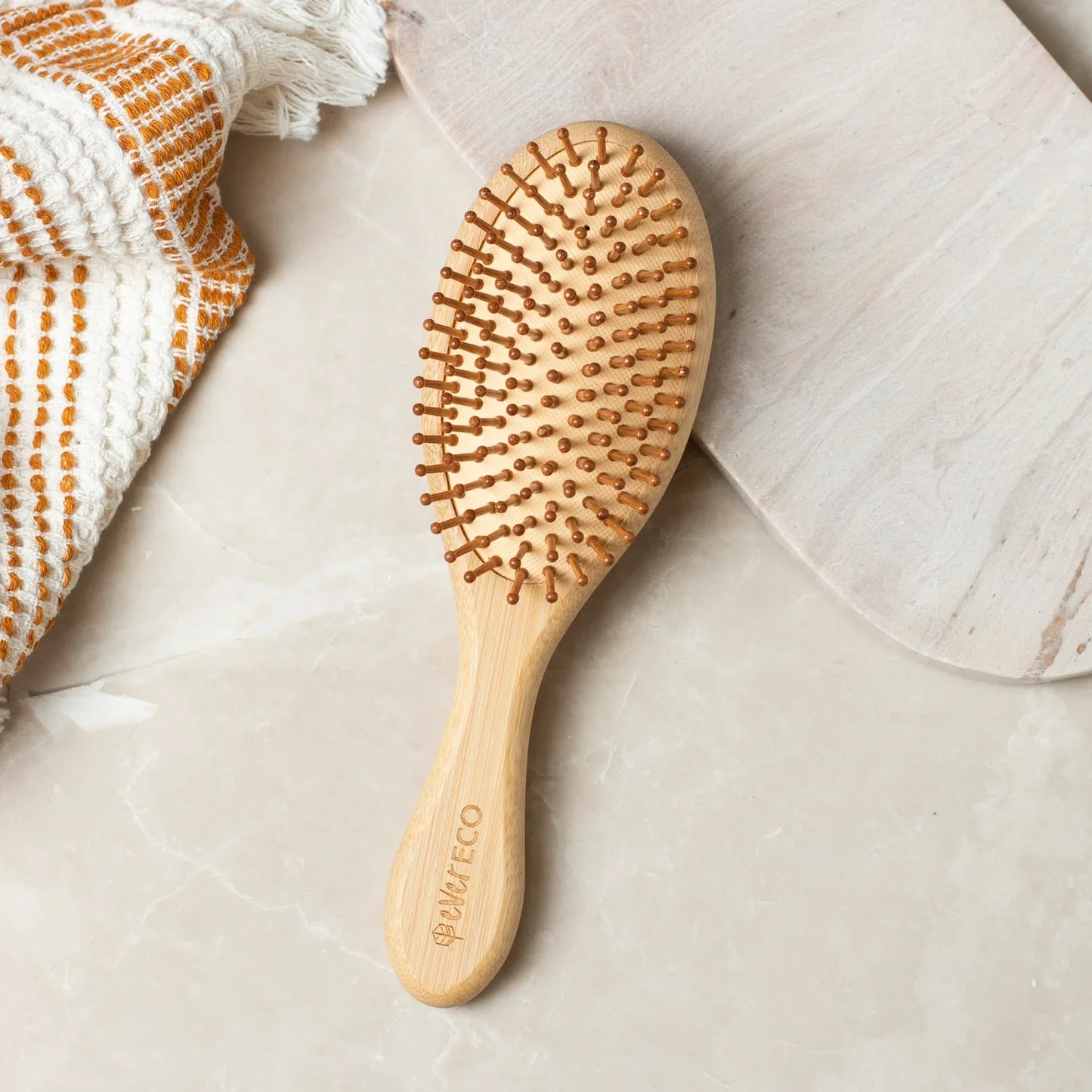 Eco-friendly bamboo hair brush with oval shape and natural rubber bristles.