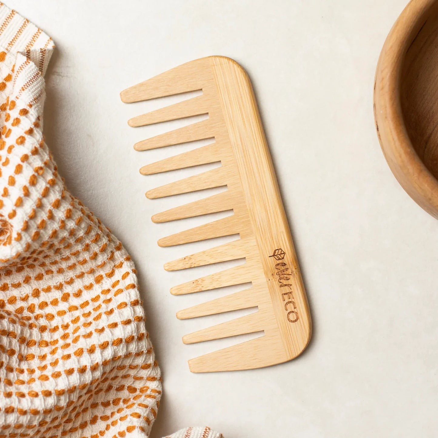 Eco-friendly wide tooth bamboo comb for detangling hair.