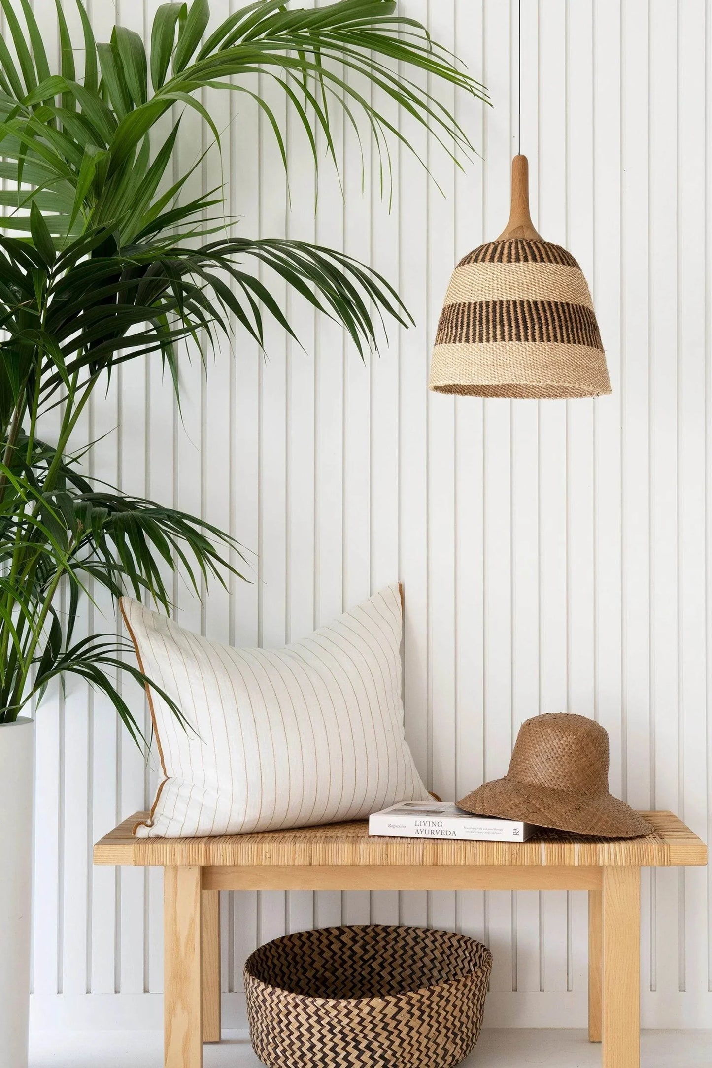 Bespoke woven pendant light with neutral tones, handmade from sisal, featuring a unique weave and wooden holder, part of the Nomadic Collection.