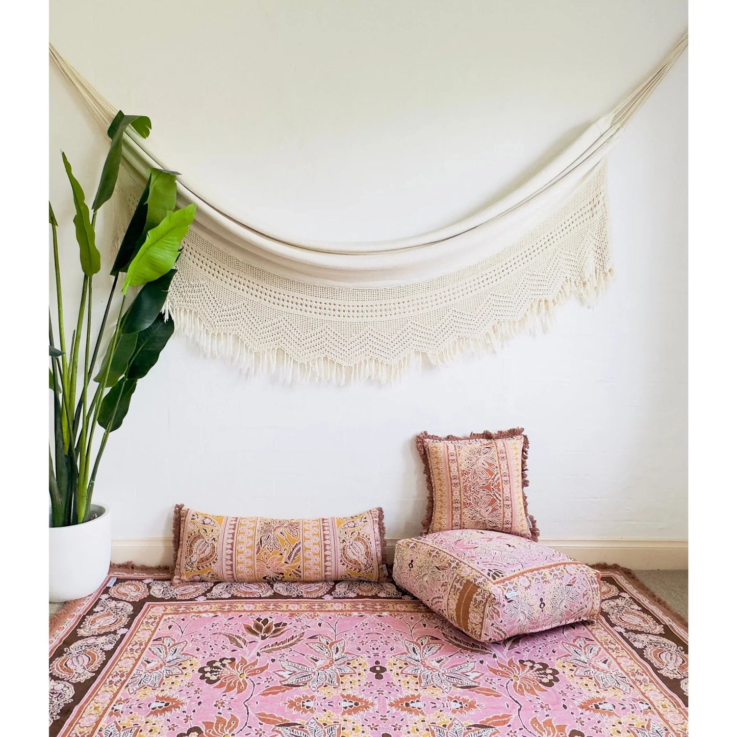 Bohemian-style Isla picnic rug with chintz Indian florals and paisley design in pink, brown, and yellow hues, featuring tassel trimming.