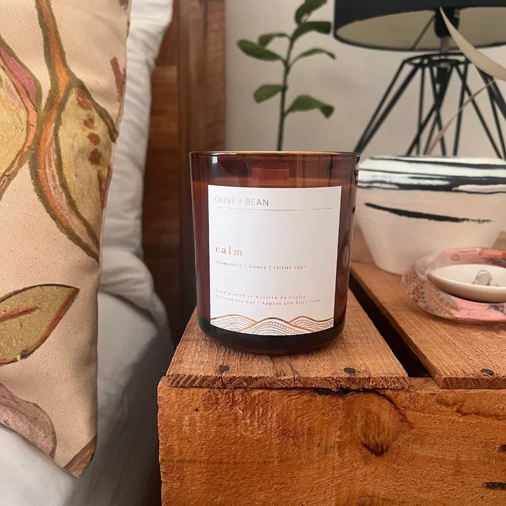 Olive & Bean Calm candle with citrus sage and chamomile notes, eco-friendly wood wick, and sustainable packaging.