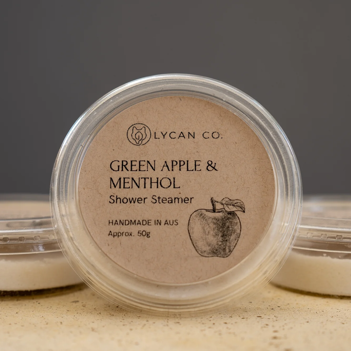 Lycan Co Green Apple and Menthol Shower Steamer in compostable packaging.
