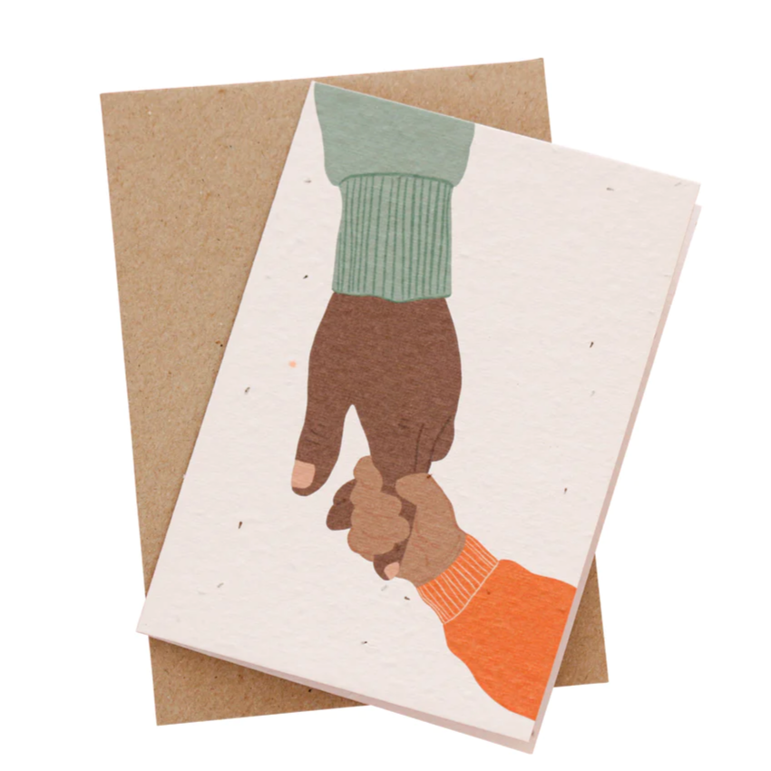 Plantable card with illustration of two hands holding, made from 100% recycled seeded paper with WA Swan River daisy seeds and a recycled paper envelope.