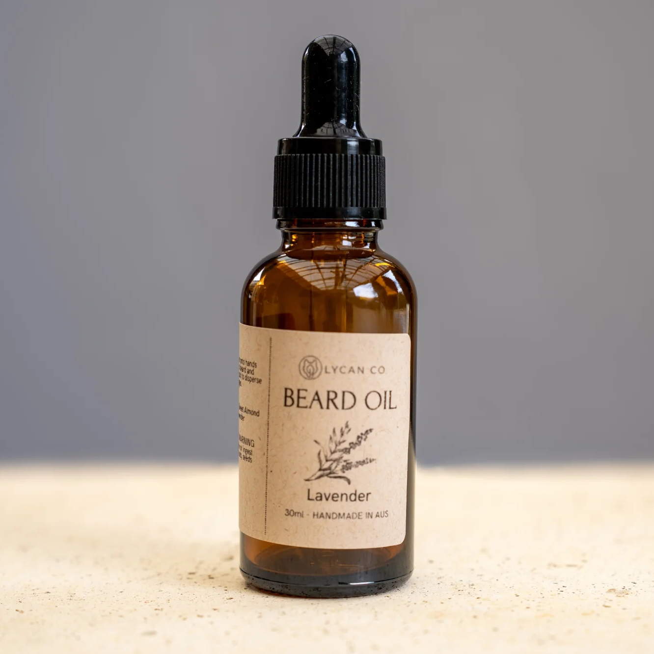Amber bottle of Lycan Co Lavender Beard Oil with dropper lid on a neutral background.