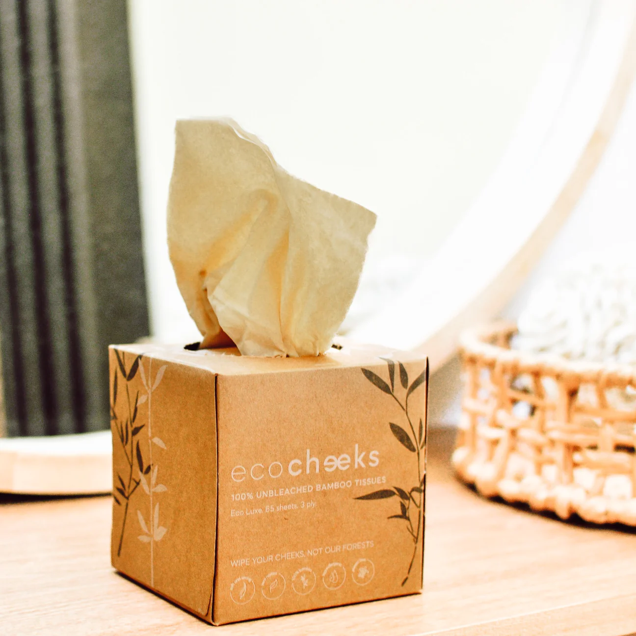 Eco-friendly bamboo tissues in cube box on wooden surface.