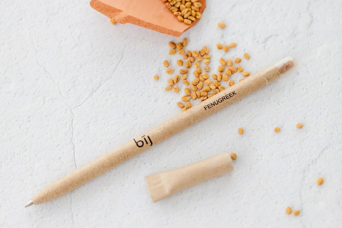 Plantable BĪJ Pen by Left Handesign, featuring fenugreek seeds, made from recycled newspaper with a cellulose capsule.