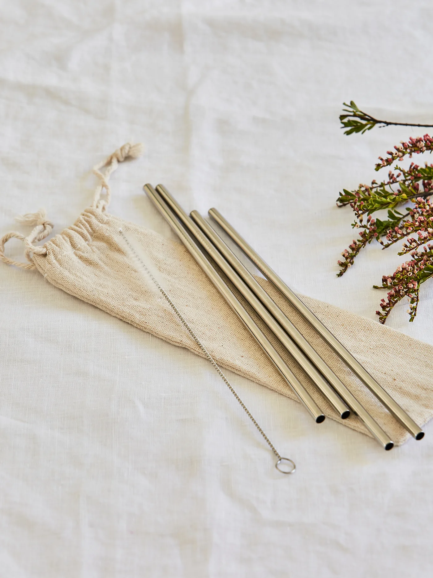 Set of 4 stainless steel reusable straws with organic cotton bag and cleaning brush.