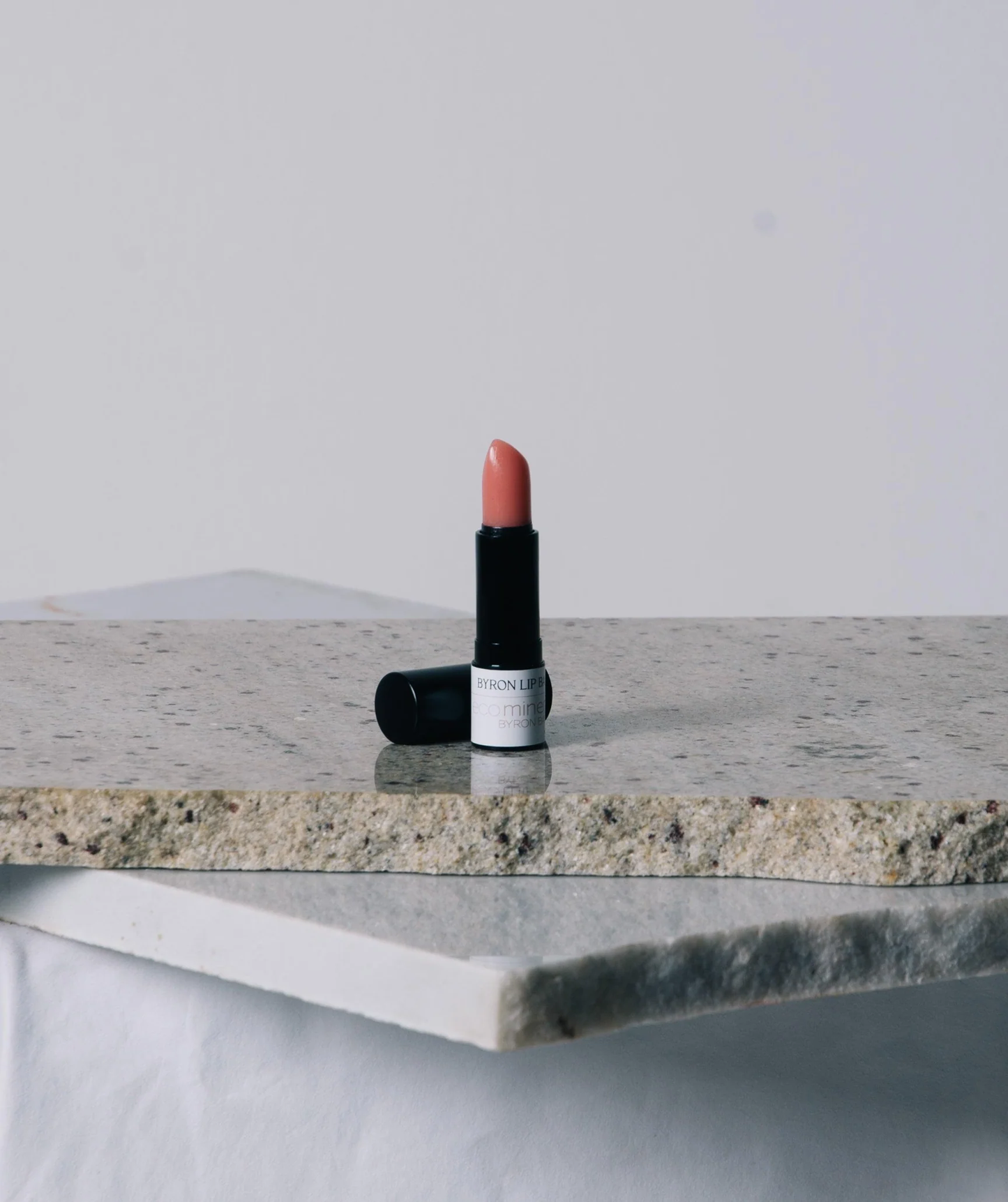 Eco Minerals Lip Balm with nourishing plant-based ingredients on a marble surface.
