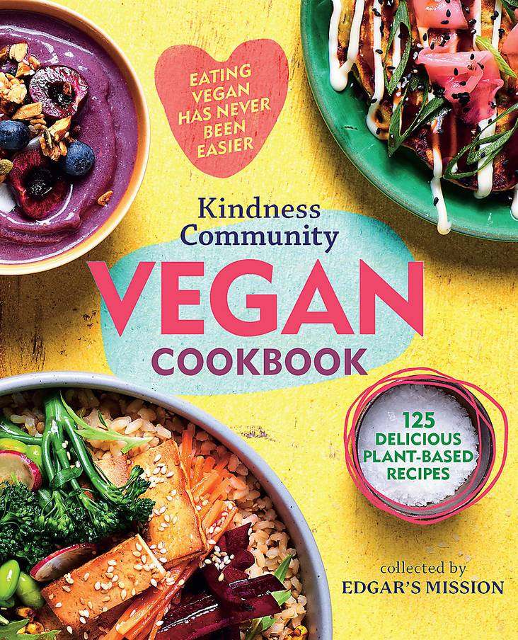 The Kindness Community Vegan Cookbook cover with colorful plant-based dishes.