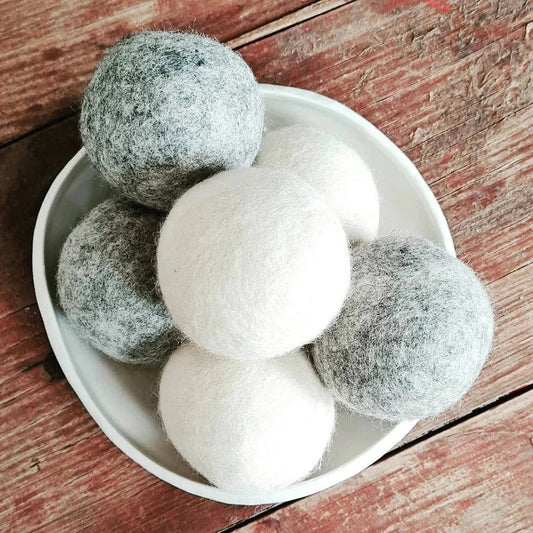 Red House wool dryer balls in a bowl, 3 grey and 3 white.