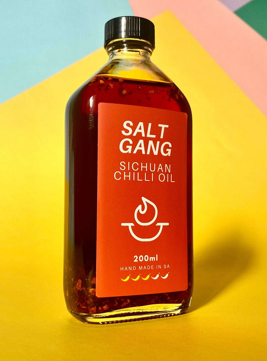 Salt Gang Sichuan Chilli Oil in 200ml glass jar with sesame seeds and chilli flakes.