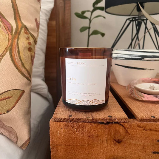 Olive & Bean Calm candle with citrus sage and chamomile notes, eco-friendly wood wick, and sustainable packaging.
