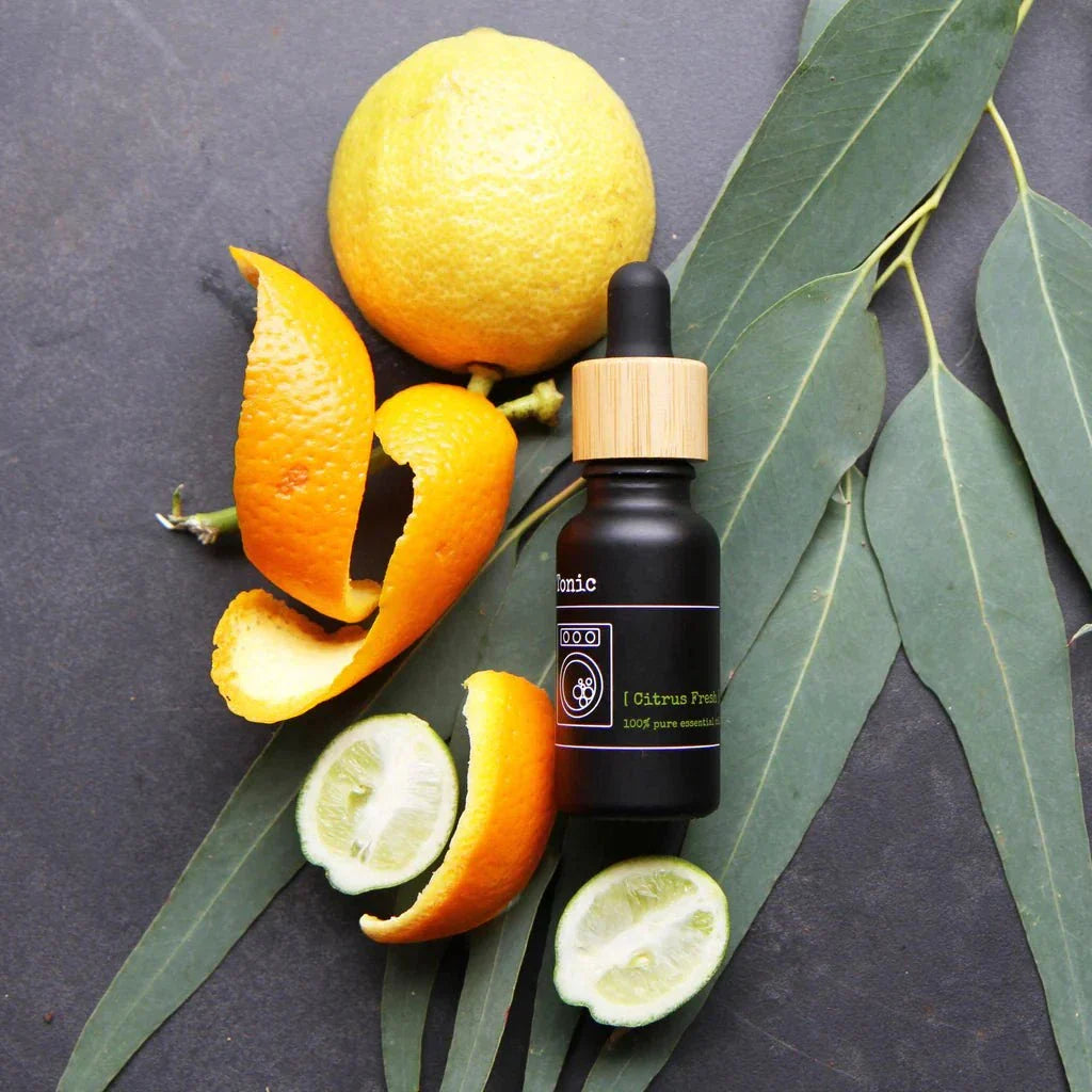 Laundry Tonic bottle with citrus fruits on eucalyptus leaves.